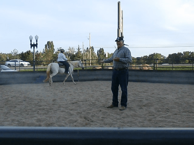 Joe in round pen with Kim riding Curl